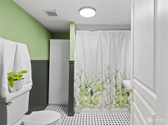 bathroom featuring curtained shower and toilet