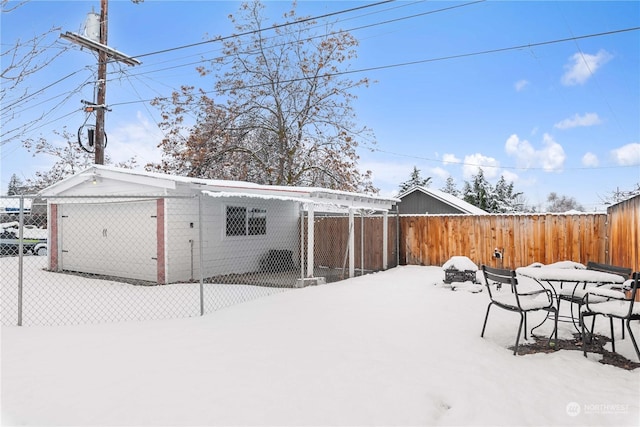 view of snow covered back of property