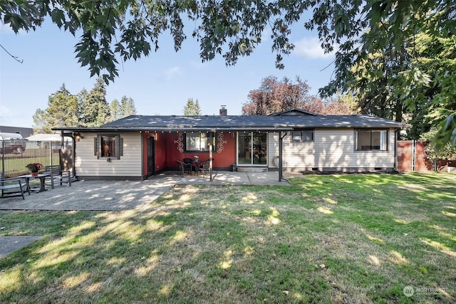 rear view of house with a yard and a patio