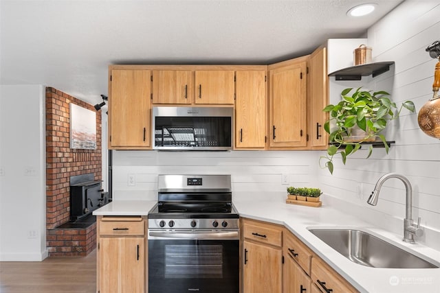 kitchen with stainless steel appliances, light hardwood / wood-style flooring, tasteful backsplash, and sink