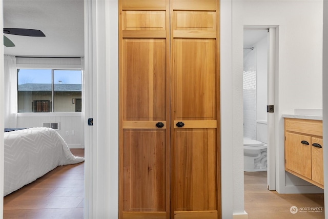 interior space with ceiling fan, wood-type flooring, toilet, and vanity