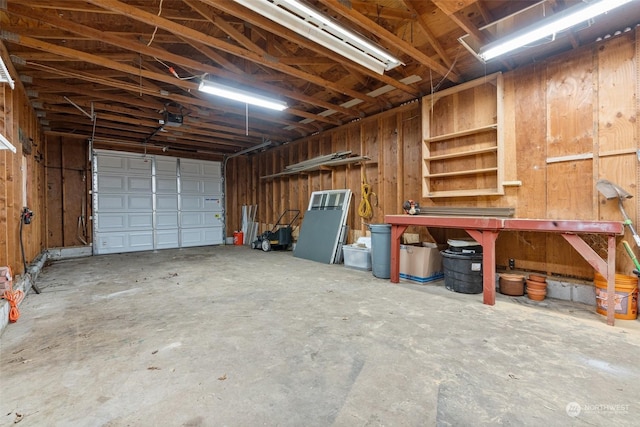 garage with a garage door opener and a workshop area