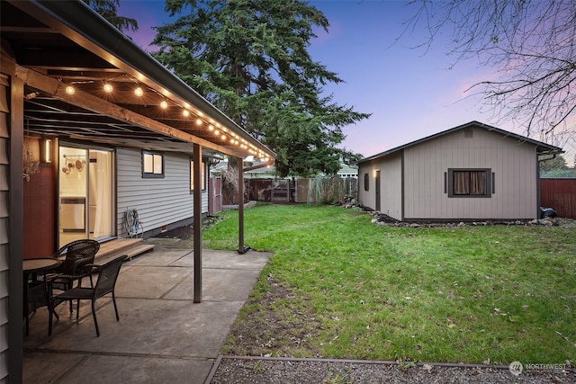 yard at dusk featuring a patio area and an outdoor structure