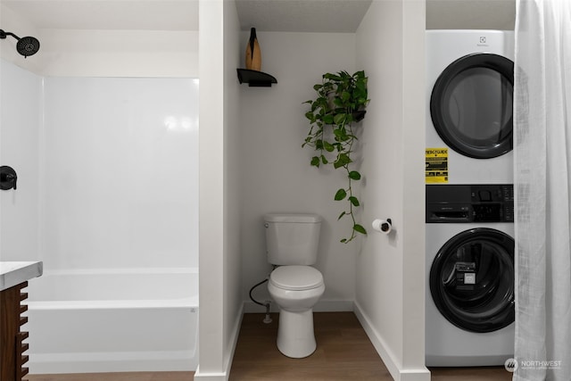 bathroom with toilet, vanity, wood-type flooring, stacked washer and clothes dryer, and a washtub