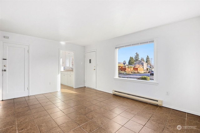 unfurnished room with a baseboard heating unit