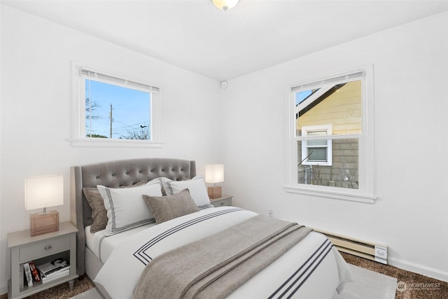 carpeted bedroom featuring a baseboard radiator and multiple windows