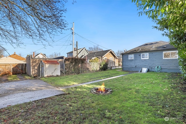 view of yard with an outdoor fire pit and a storage shed