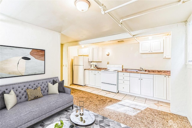 kitchen with white cabinets, white appliances, light colored carpet, and sink