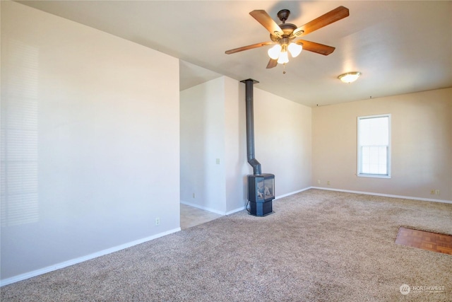 interior space with a wood stove and ceiling fan