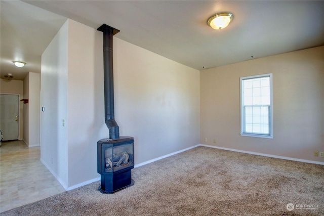 unfurnished living room with carpet flooring and a wood stove