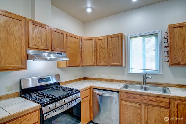 kitchen featuring appliances with stainless steel finishes, tile counters, and sink