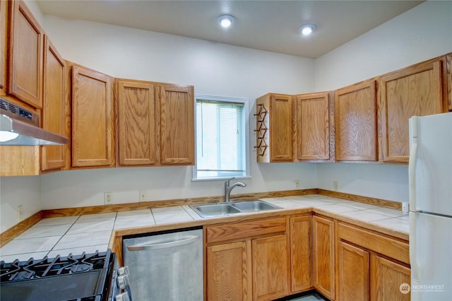 kitchen with dishwasher, sink, range hood, tile counters, and white fridge