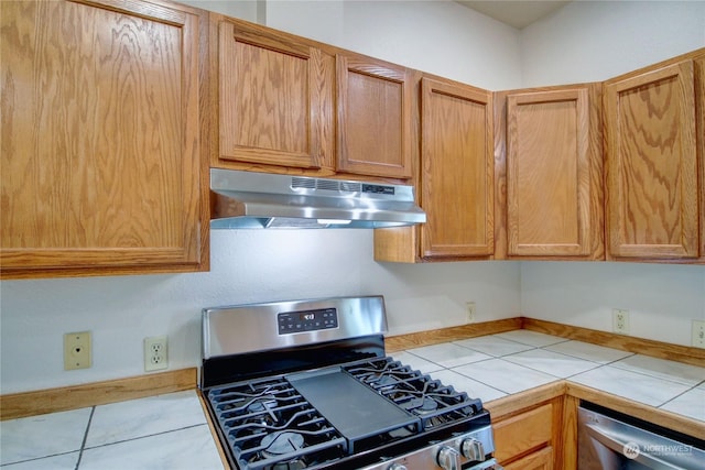 kitchen featuring tile counters, light tile patterned floors, and stainless steel appliances