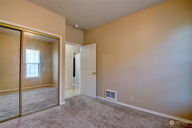 unfurnished bedroom featuring carpet floors and a closet