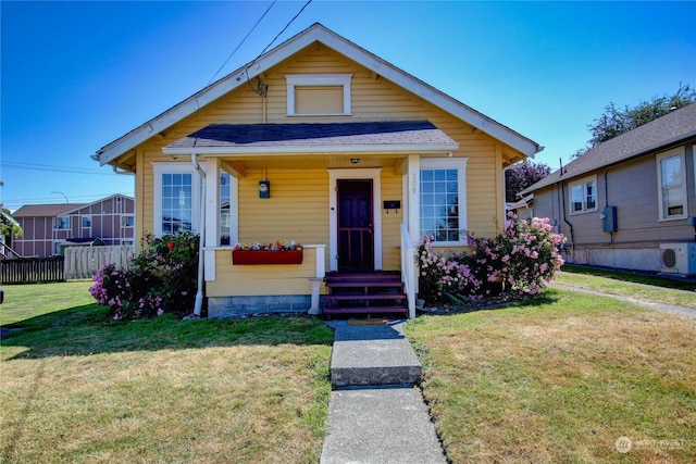 bungalow with a front yard and ac unit