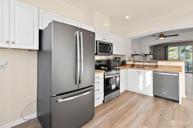 kitchen with stainless steel appliances, white cabinetry, and sink