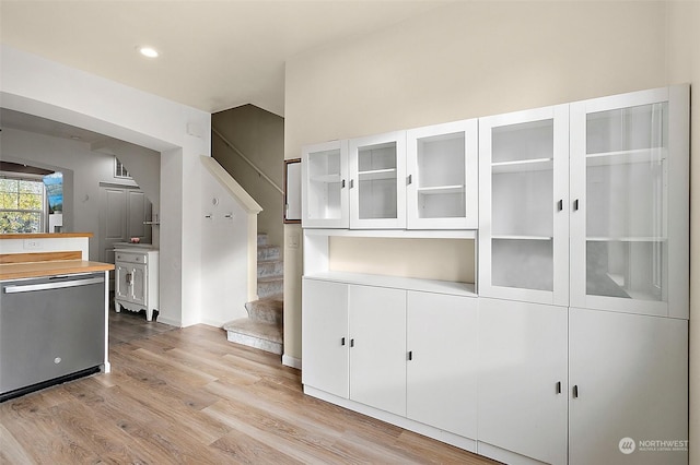 kitchen with white cabinets, dishwasher, and light wood-type flooring