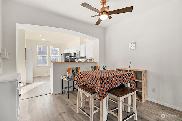 dining room with light hardwood / wood-style flooring and ceiling fan