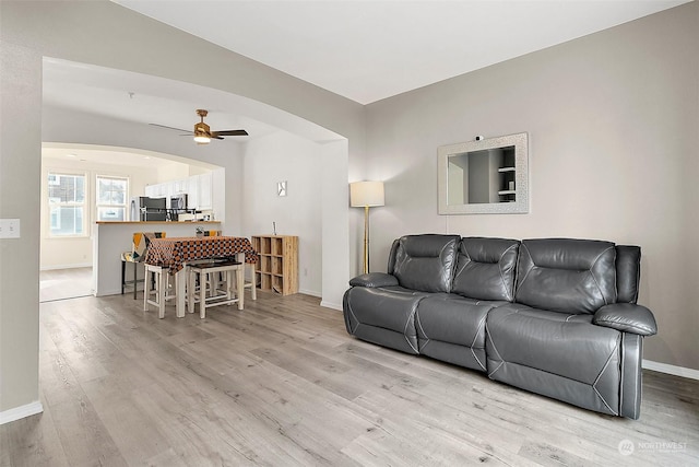 living room featuring ceiling fan and light wood-type flooring