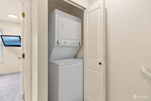 laundry room featuring carpet flooring and stacked washer / dryer