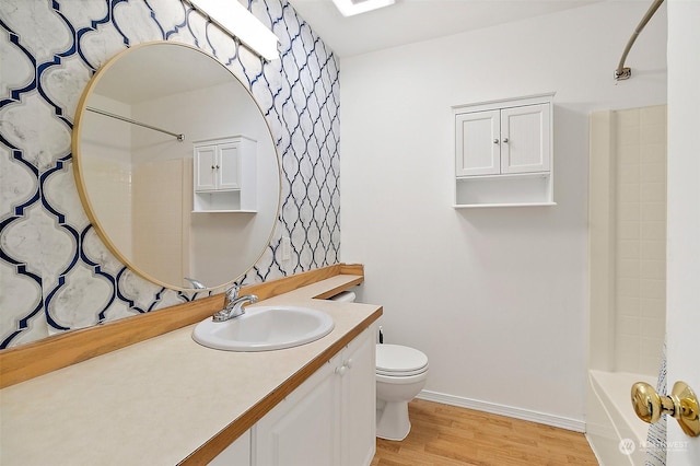 full bathroom featuring hardwood / wood-style flooring, vanity, shower / bathtub combination, and toilet