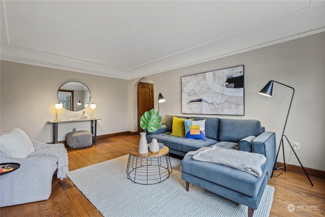 living room with wood-type flooring and ornamental molding