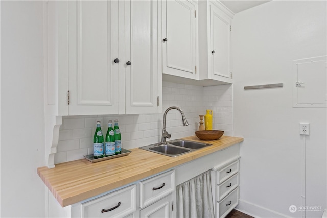 kitchen featuring backsplash, white cabinetry, and sink