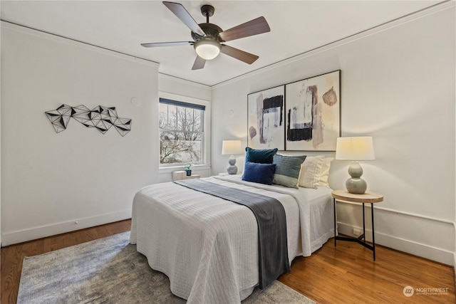 bedroom with ceiling fan, hardwood / wood-style floors, and crown molding