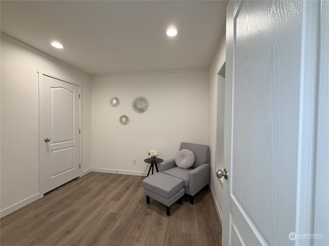 sitting room with hardwood / wood-style flooring and ornamental molding