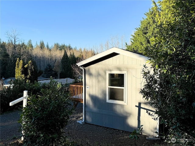 view of home's exterior with a deck and an outdoor structure