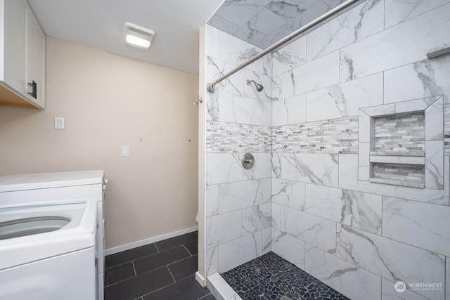 bathroom featuring tile patterned flooring, a tile shower, and separate washer and dryer