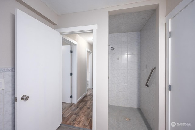 bathroom featuring tiled shower and hardwood / wood-style flooring