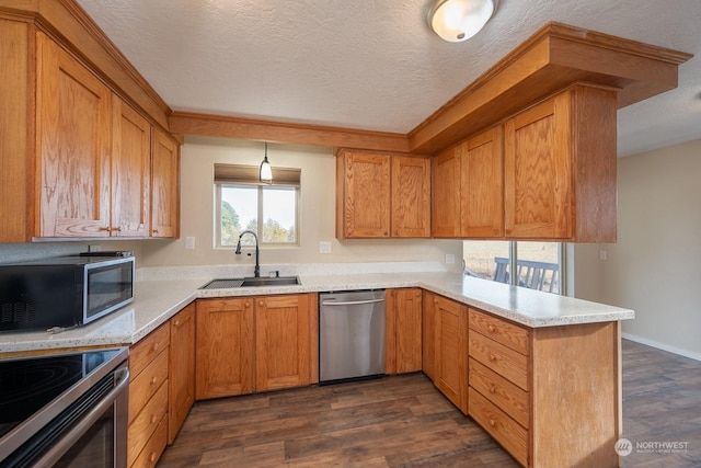 kitchen with a textured ceiling, sink, appliances with stainless steel finishes, and dark wood-type flooring