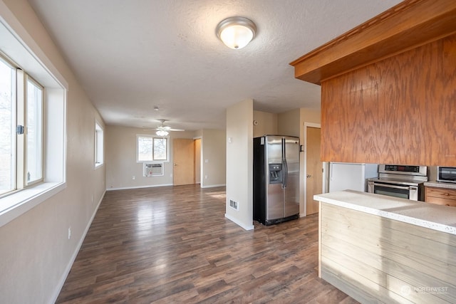 kitchen featuring a textured ceiling, ceiling fan, dark hardwood / wood-style floors, and appliances with stainless steel finishes