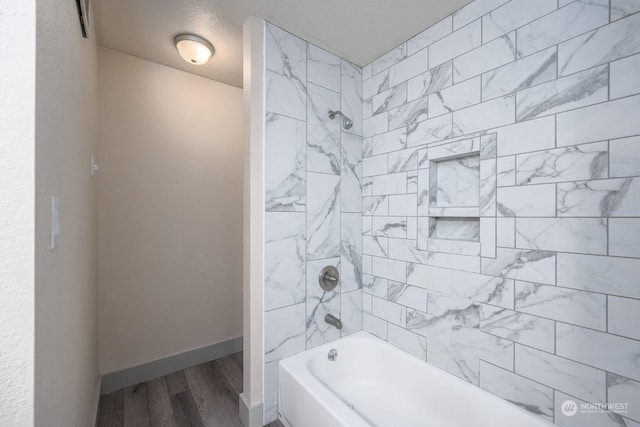 bathroom featuring wood-type flooring and tiled shower / bath combo