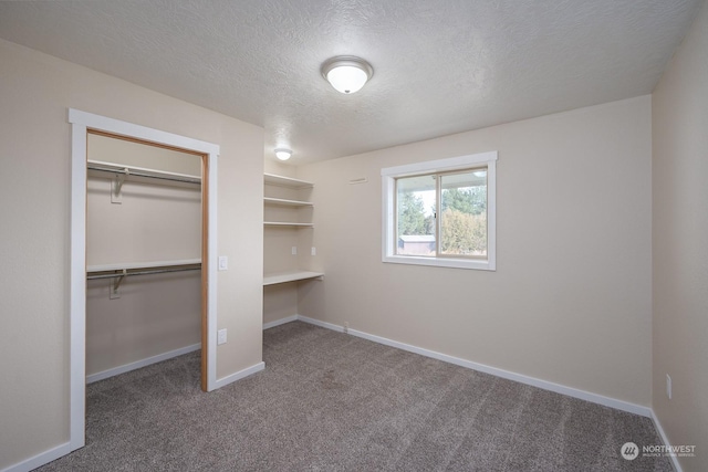 unfurnished bedroom with carpet flooring, a closet, and a textured ceiling