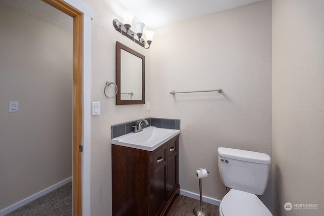 bathroom with vanity, hardwood / wood-style flooring, and toilet