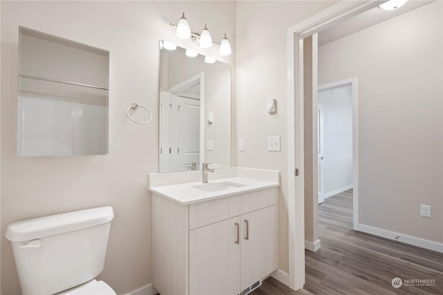 bathroom with vanity, wood-type flooring, and toilet