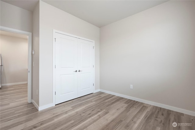 unfurnished bedroom featuring a closet and light wood-type flooring