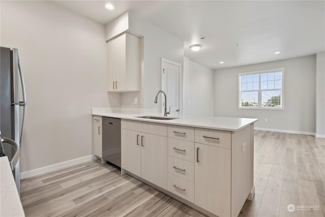 kitchen with light hardwood / wood-style floors, kitchen peninsula, sink, and appliances with stainless steel finishes