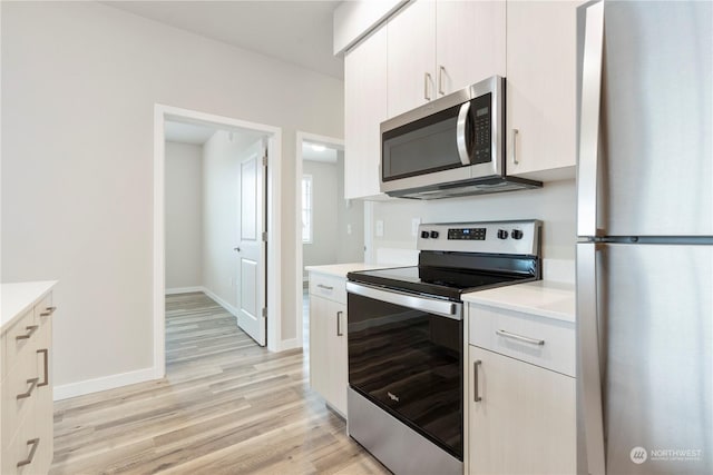 kitchen featuring white cabinetry, stainless steel appliances, and light hardwood / wood-style floors