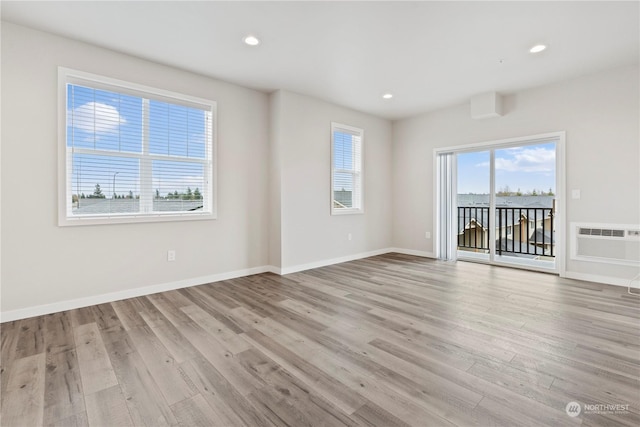 unfurnished room featuring light hardwood / wood-style flooring and a wall mounted AC