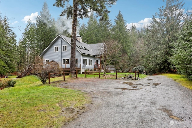 view of front facade with a front yard and a wooden deck