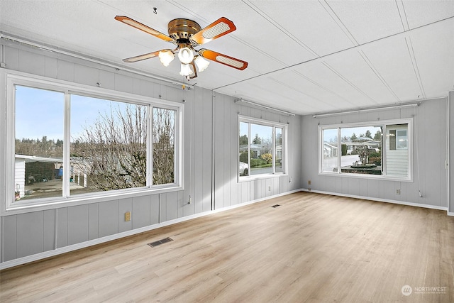 unfurnished sunroom featuring ceiling fan