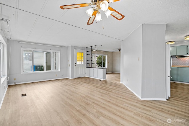 unfurnished living room with a textured ceiling, light wood-type flooring, and ceiling fan