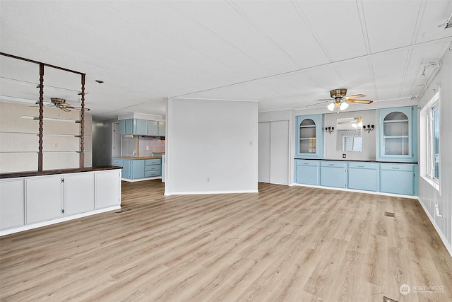 unfurnished living room featuring ceiling fan and light wood-type flooring