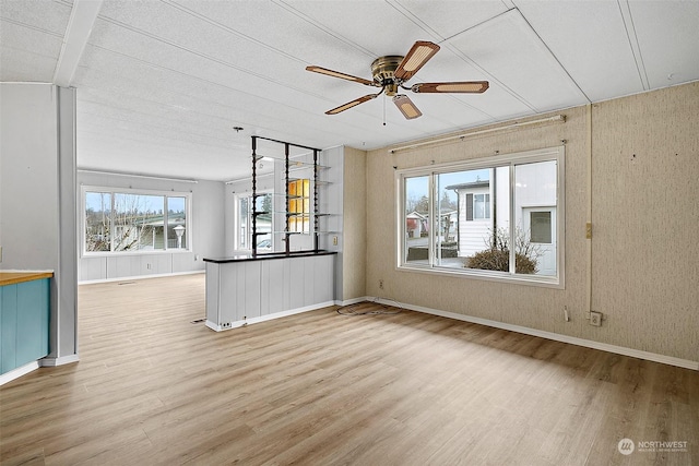 unfurnished living room with ceiling fan, a textured ceiling, and light hardwood / wood-style flooring