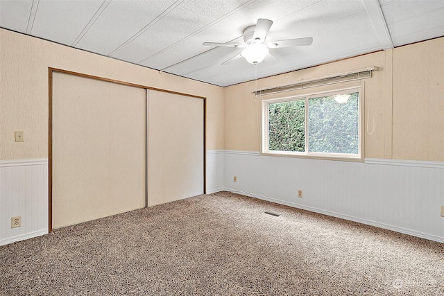 unfurnished bedroom with carpet, a textured ceiling, a closet, and ceiling fan