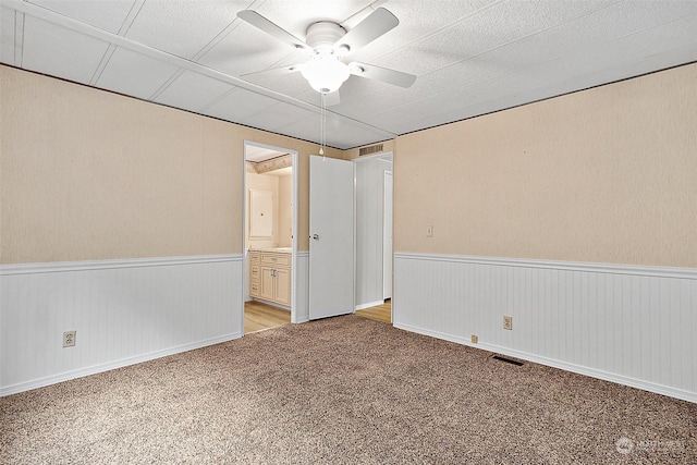 carpeted spare room with ceiling fan