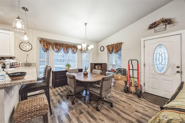 dining room with vaulted ceiling, dark hardwood / wood-style floors, and a chandelier